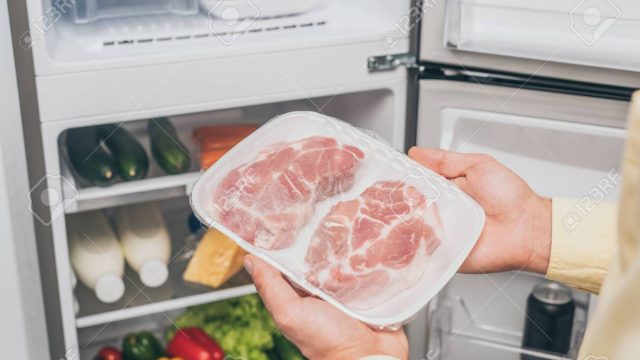 135876004-cropped-view-of-man-holding-frozen-meat-near-open-fridge-full-of-food.jpg